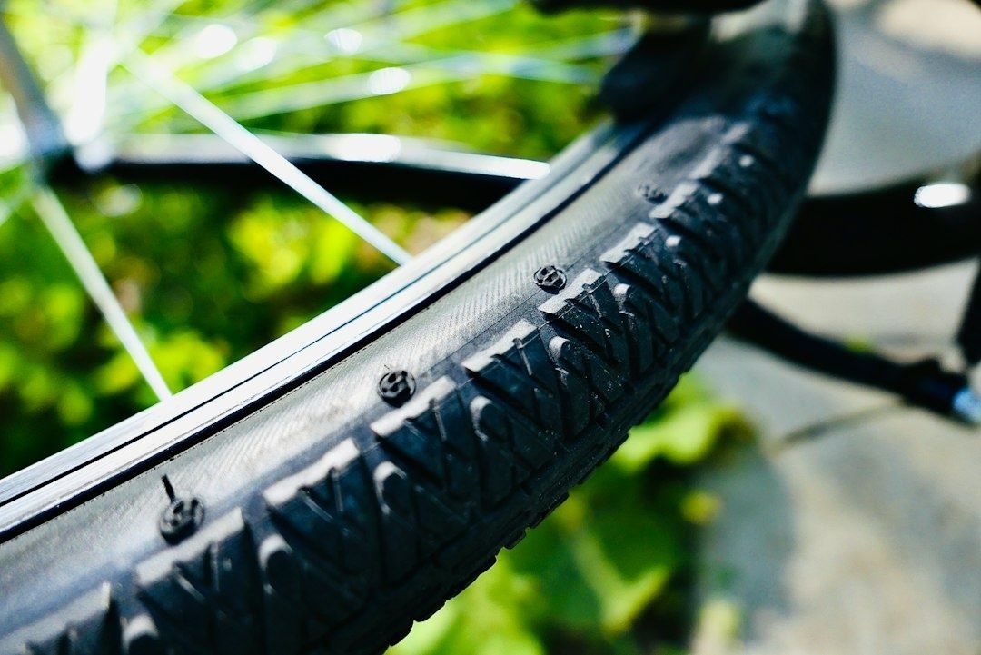 Nahaufnahme eines Fahrradreifens mit grobem Profil und sichtbaren Reifenstopfen