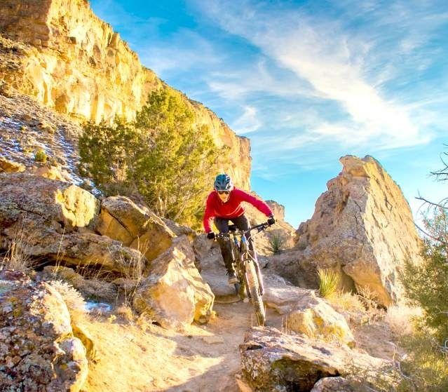 Mountainbiker fährt eine enge, steile Kurve zwischen Felsen hinab