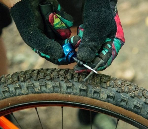 Mountainbike-Reifen wird mit einem Reifenstopfen-Werkzeug repariert